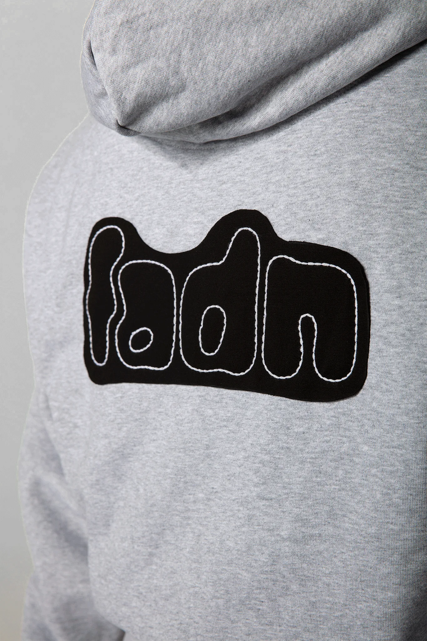 Grauer Hoodie mit gesticktem fadn Patch